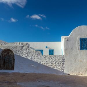 Explore the charming traditional architecture of Takrouna, Tunisia, featuring whitewashed walls and blue accents.